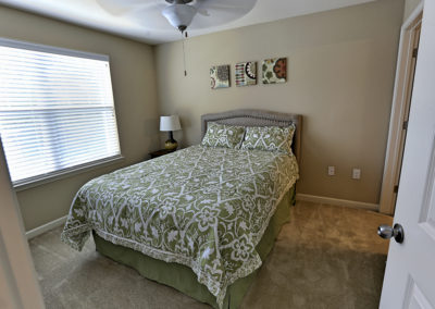 Stallion Pointe master bedroom with queen bed and green comforter