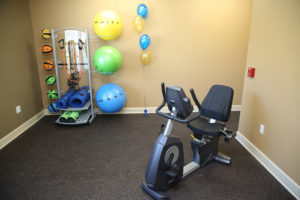 Fitness room at Stallion Pointe with a stationary bike, medicine balls, bosu balls, and workout mats